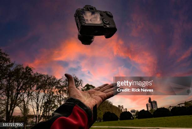 floating photo camera in dramatic sky, photograph concept - videoshoot stockfoto's en -beelden