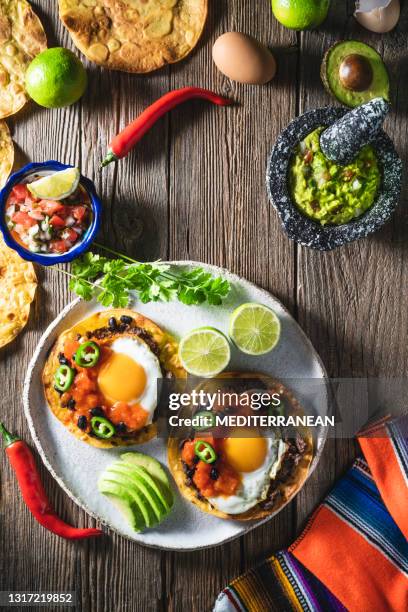 huevos rancheros are mexican ranchero eggs breakfast with pico de gallo and guacamole - mexican rustic stock pictures, royalty-free photos & images