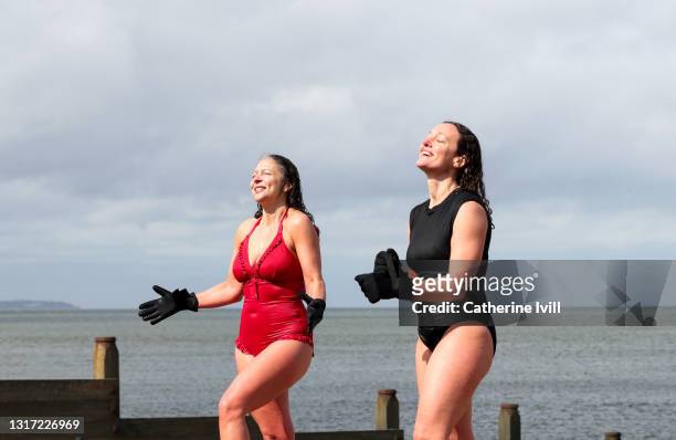 women come out of the water after open water swimming - menopossibilities fotografías e imágenes de stock