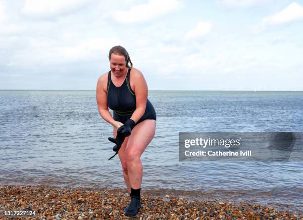 woman comes out of the water after open water swimming - open water swimming stock pictures, royalty-free photos & images