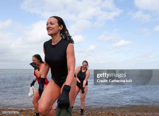 women come out of the water after open water swimming - menopossibilities fotografías e imágenes de stock