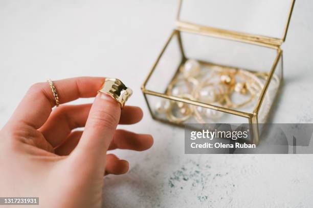 a woman's hand holds a gold ring - リング ストックフォトと画像