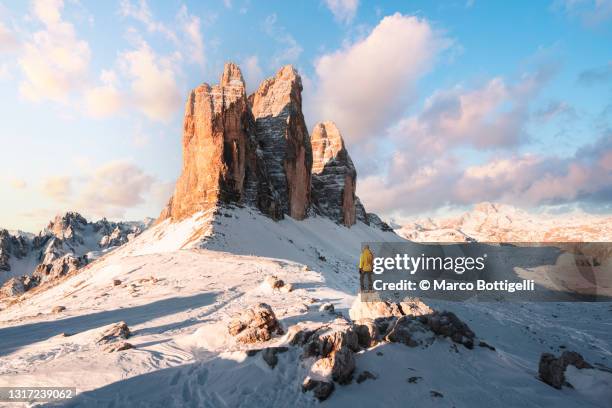 tourist admiring the three peaks of lavaredo in winter, italy - italy winter stock pictures, royalty-free photos & images