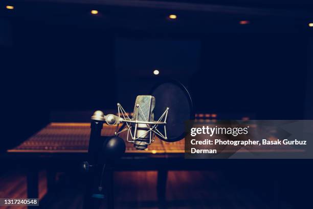 a microphone in a recording studio in front of a mixing console - recording studio stock pictures, royalty-free photos & images