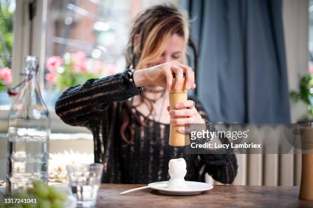 young woman with a unique and personal style putting salt on a boiled egg - hard boiled eggs stock pictures, royalty-free photos & images