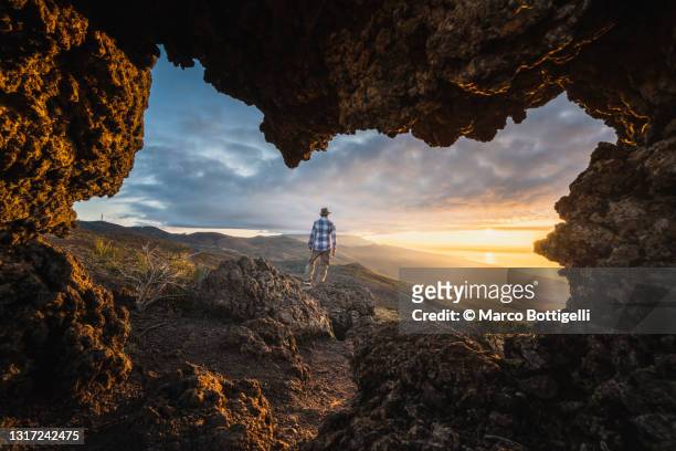 person admiring sunset in teide national park - verwonderingsdrang stockfoto's en -beelden