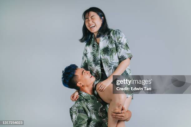 playful asian chinese boyfriend carrying girlfriend on shoulder summer wear studio shoot cut out with gray background - piggyback stock pictures, royalty-free photos & images