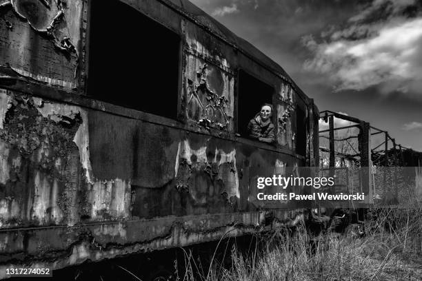 boy wearing mask in destroyed train wagon - burnt metal stock pictures, royalty-free photos & images