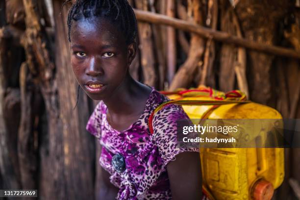 afrikanisches mädchen, das wasser aus dem brunnen trägt, äthiopien, afrika - african girl drinking water stock-fotos und bilder