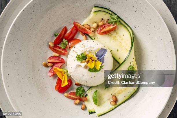 burrata with sliced zucchini with tomatoes and a pesto dressing. - mozzarella stock pictures, royalty-free photos & images