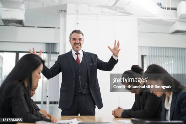 businessman scolding employees during meeting in the office. - chef schreit stock-fotos und bilder