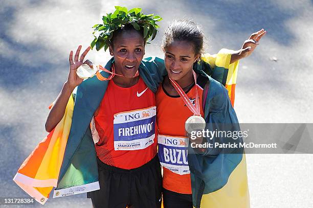 Firehiwot Dado of Ethiopia celebrates with Buzunesh Deba of Ethiopia after finishing in first and second place in the Women's Division of the 42nd...