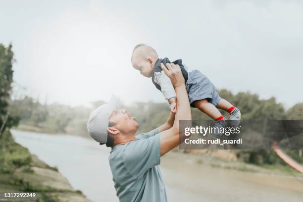 real father and baby in rural on summer day - baby father hug side stock pictures, royalty-free photos & images