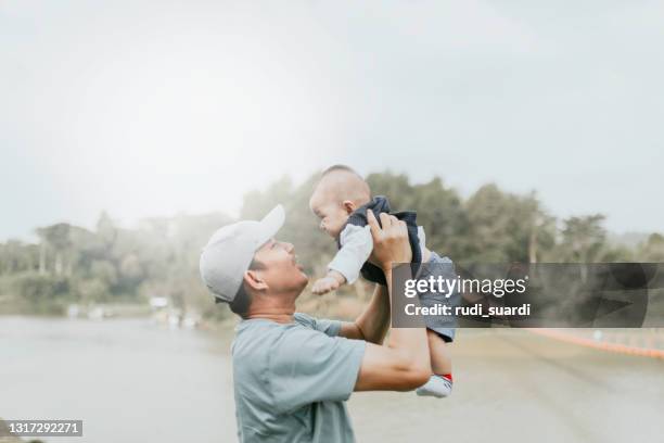 real father and baby in rural on summer day - baby father hug side stock pictures, royalty-free photos & images