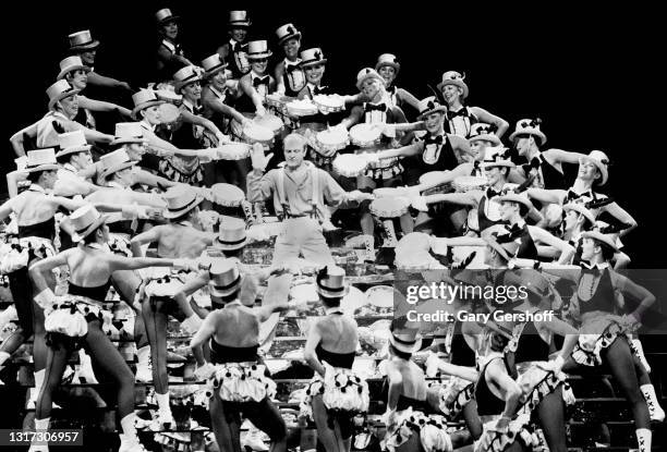 Australian musician and enterainer Peter Allen , with members of the Rockettes dance troupe, performs onstage at Radio City Music Hall, New York, New...