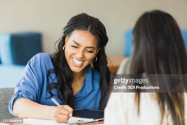 female business owner smiles while conducting interview - job interview stock pictures, royalty-free photos & images