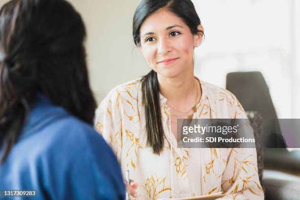 compassionate female therapist listens to unrecognizable female client - emotional support stock pictures, royalty-free photos & images