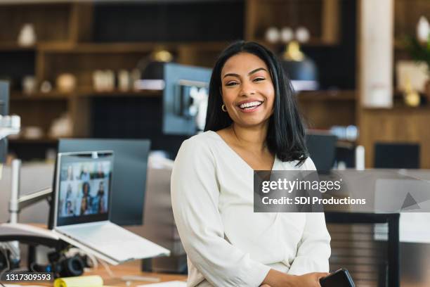 female business owner poses for photo at work - hispanic businesswoman stock pictures, royalty-free photos & images