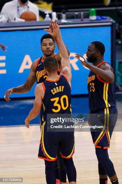 Golden State Warriors players Stephen Curry, Kent Bazemore and Draymond Green celebrate after a play in the second quarter against the Oklahoma City...