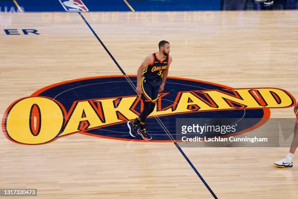 Stephen Curry of the Golden State Warriors crosses the 'Oakland' logo at mid-court during the game against the Oklahoma City Thunder at Chase Center...
