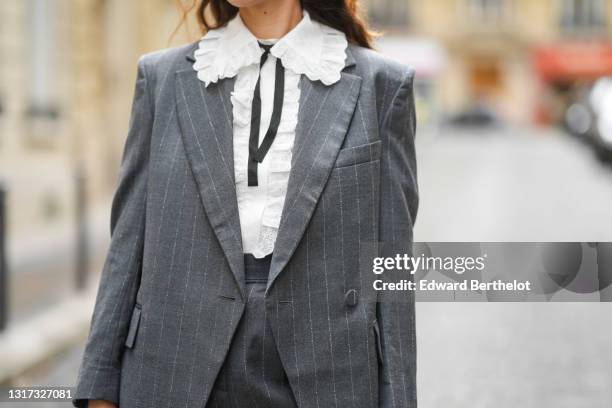 Ketevan Giorgadze @katie.one wears gray tailored tapered pinstripe wool trousers from &OtherStories, a gray oversized asymmetric pinstripe blazer...