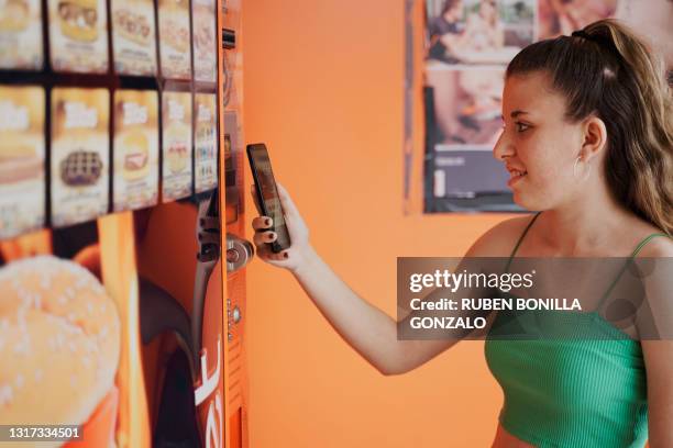 caucasian woman paying with smartphone at vending machine. - pattie sellers stock pictures, royalty-free photos & images