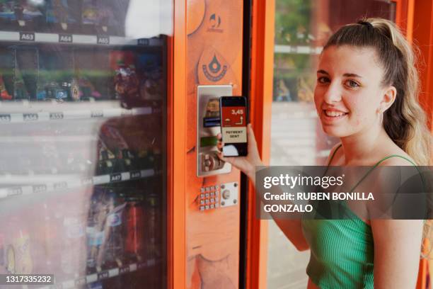 caucasian woman paying with smartphone at vending machine. - pattie sellers stock pictures, royalty-free photos & images