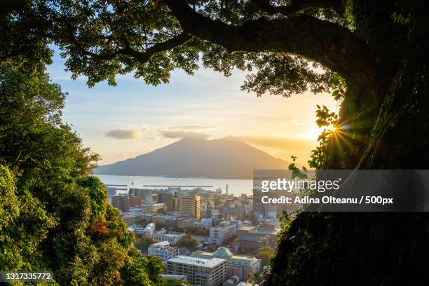 scenic view of townscape by sea against sky during sunset - kagoshima prefecture fotografías e imágenes de stock