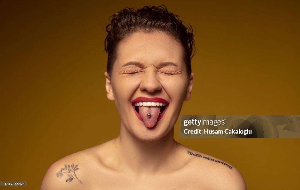The young woman with a piercing on her tongue closed her eyes and stuck her tongue out.