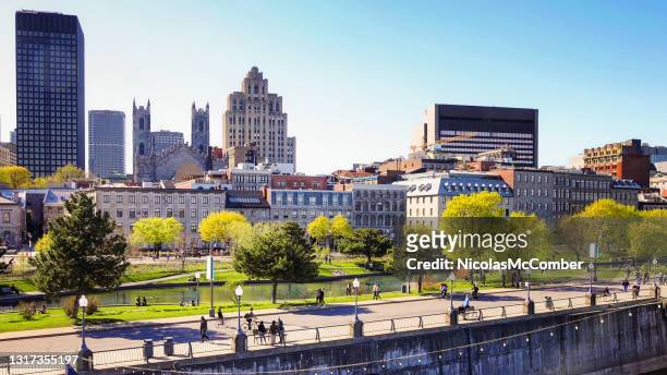 vieux port de montreal and downtown skyline with promenade pier on a clear may springtime day - montréal stock pictures, royalty-free photos & images