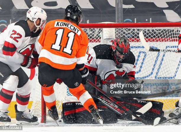 Scott Wedgewood of the New Jersey Devils makes the chest save as Travis Konecny of the Philadelphia Flyers looks for the rebound during the second...