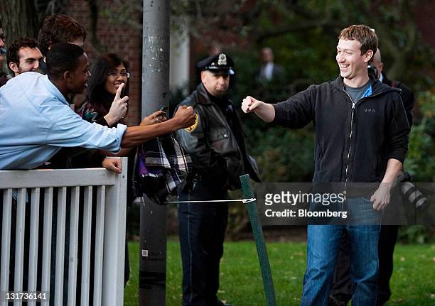 Mark Zuckerberg, founder and chief executive officer of Facebook Inc., right, greets a student while arriving to speak during a news conference at...
