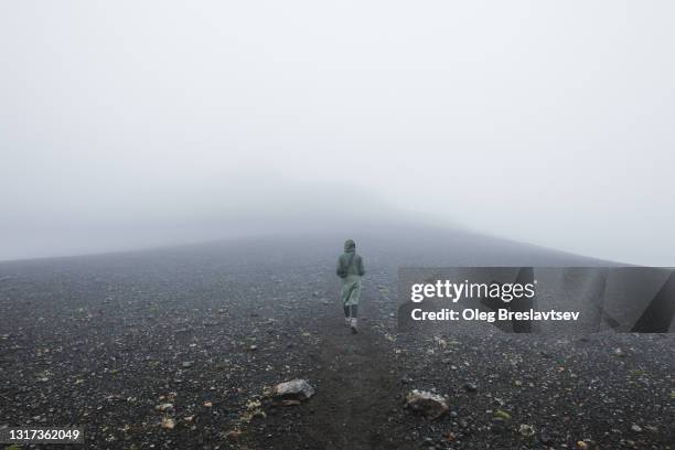 woman hiking alone in iceland ash volcanic field desert lakagigar. foggy weather, mystical mood. minimalism - smog stock pictures, royalty-free photos & images