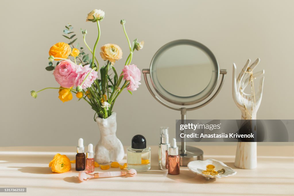 Mirror and cosmetic products on female table at home.