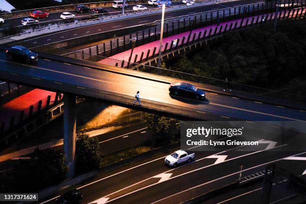 Woman walks alone at dusk on May 10, 2021 in Auckland, New Zealand. Auckland Council’s long term plan, a 10-year list of transport projects and...