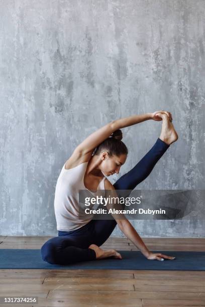 yoga practice yoga woman exercising her body on the mat - yoga flexibility stock pictures, royalty-free photos & images