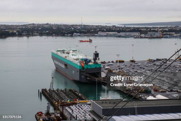 Wallenius Wilhemsen cargo ship is tied up at Ports of Auckland downtown port at sunrise on May 10, 2021 in Auckland, New Zealand, next to rows of...
