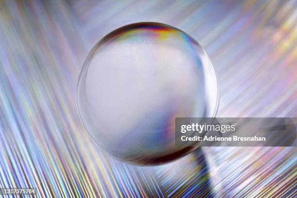 clear glass marble on textured foil - metallic liquid stock pictures, royalty-free photos & images