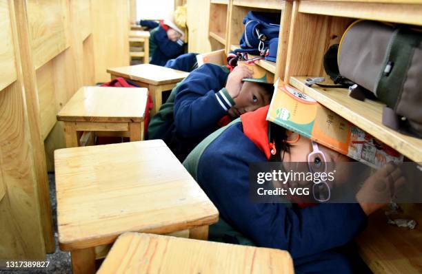 Students take part in an earthquake drill to mark China's national day for disaster prevention and relief, which commemorates the 2008 Wenchuan...