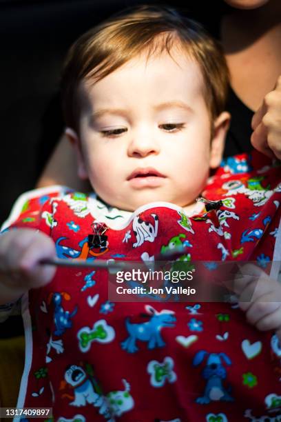 foto vertical de un niño de menos de dos años, está en la consulta del dentista con una bata roja mientras se mira en un pequeño espejo que el niño sostiene en la mano. - 35 39 años stock pictures, royalty-free photos & images