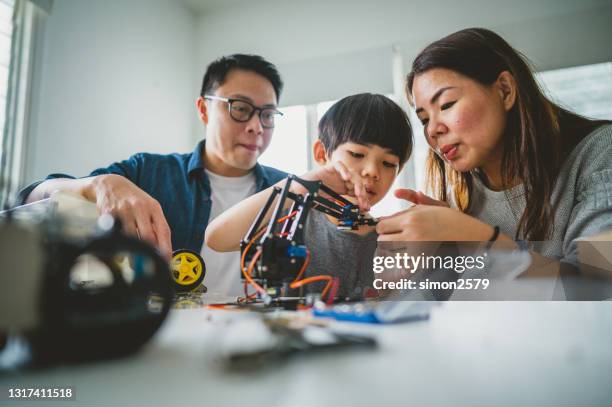 asian family enjoying their robotic hobby at home - connected mindfulness work stock pictures, royalty-free photos & images