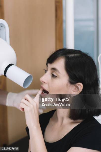 el dentista coloca la máquina de rayos x para que el paciente tenga una radiografía del lado de los dientes. - doctor paciente stockfoto's en -beelden