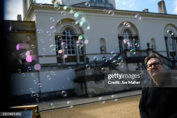 Mark Wallinger stands with a bubble machine which sits beside his artwork 'British Summer Time ' during the "Bring into Being" Press Launch on May...