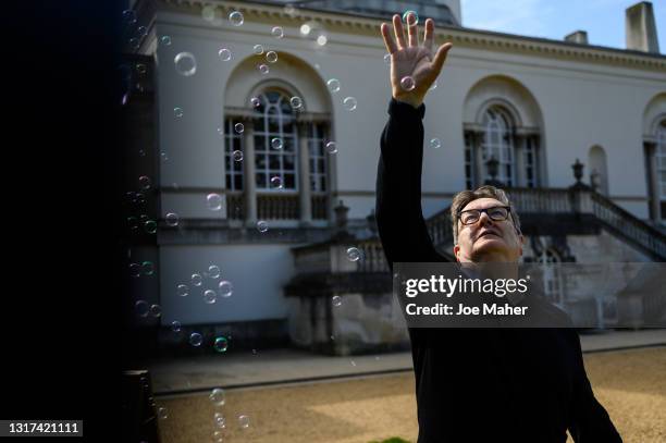 Mark Wallinger stands with a bubble machine which sits beside his artwork 'British Summer Time ' during the "Bring into Being" Press Launch on May...