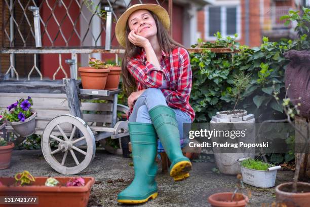 portrait of happy female gardener in her home small garden at balcony - autarkie stockfoto's en -beelden