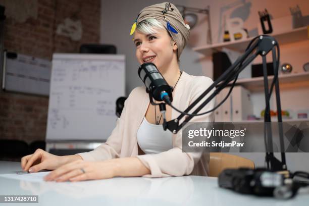 low-angle view of a beautiful female radio commentator at the radio station - radio studio stock pictures, royalty-free photos & images