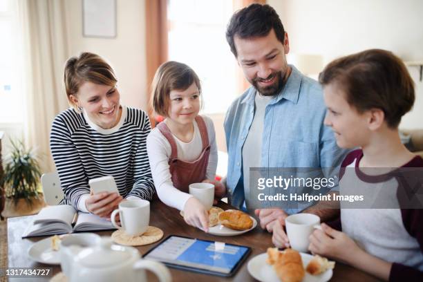 family with small children at home planning holiday, using tablet. - breakfast fathers bildbanksfoton och bilder