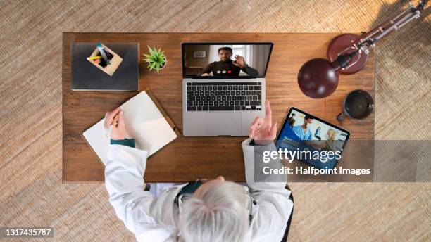 top view of senior doctor having video call with patient at home, telemedicine. - 21 & over stock pictures, royalty-free photos & images