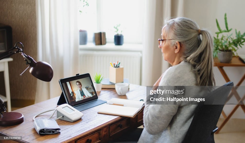 Depressed senior woman having video call with therapist, telemedicine and online therapy.