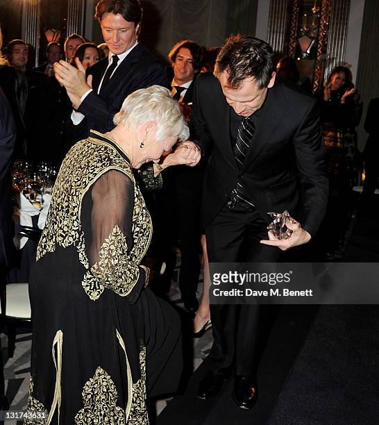 Dame Judi Dench is escorted to the stage by Michael Grandage at the Harper's Bazaar Women Of The Year Awards in association with Estee Lauder and...